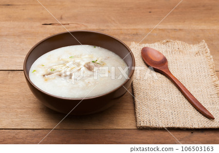 Traditional chinese porridge rice gruel in brown bowl with wooden spoon 106503163