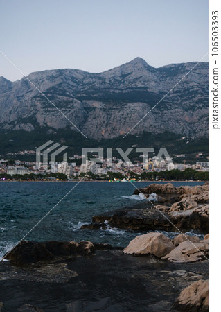 Midnight photo of old town in mountains though the cliff on the other side of coast 106503393