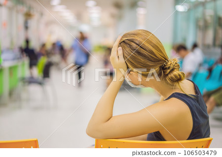 Young woman sitting in hospital waiting for a doctor's appointment. Patients In Doctors Waiting Room Young woman sitting in hospital waiting for a doctor's appointment. Patients In Doctors Waiting Room 106503479