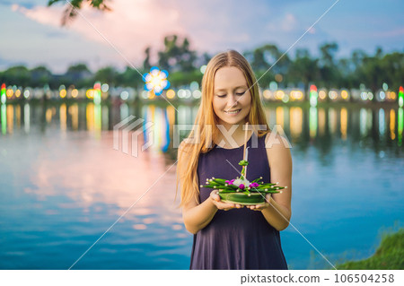 Young woman celebrates Loy Krathong, Runs on the water. Loy Krathong festival, People buy flowers and candle to light and float on water to celebrate the Loy Krathong festival in Thailand Young woman celebrates Loy Krathong, Runs on the water. Loy Krathong festival, People buy flowers and candle to light and float on water to celebrate the Loy Krathong festival in Thailand 106504258