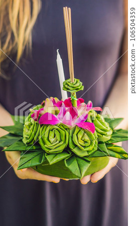 Young woman celebrates Loy Krathong, Runs on the water. Loy Krathong festival, People buy flowers and candle to light and float on water to celebrate the Loy Krathong festival in Thailand VERTICAL 106504359