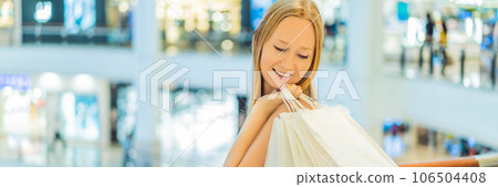 Women carrying a lot of shopping bags in blurred shopping mall BANNER, LONG FORMAT 106504408