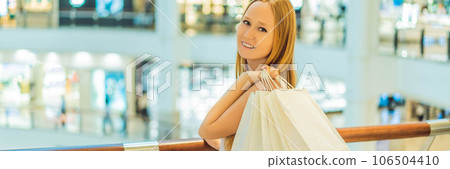 Women carrying a lot of shopping bags in blurred shopping mall BANNER, LONG FORMAT 106504410