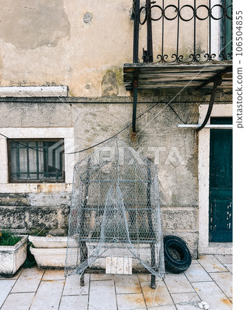 Traditional net fishing trap dries near an old stone house Traditional net fishing trap dries near an old stone house 106504855