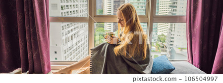 Woman wrapped in a blanket and looking at the big city BANNER, LONG FORMAT 106504997