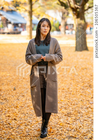 Young woman enjoying autumn leaves hunting 106505367