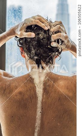 Handsome man in the shower behind glass with drops on the background of a window with a panoramic view of the city VERTICAL FORMAT for Instagram mobile story or stories size. Mobile wallpaper 106505622