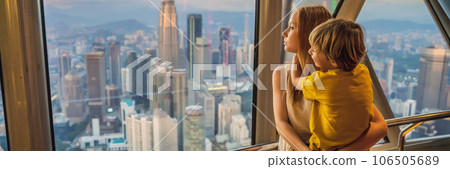 Mom and son are looking at Kuala lumpur cityscape. Panoramic view of Kuala Lumpur city skyline evening at sunset skyscrapers building in Malaysia. Traveling with kids concept BANNER, LONG FORMAT Mom and son are looking at Kuala lumpur cityscape. Panoramic view of Kuala Lumpur city skyline evening at sunset skyscrapers building in Malaysia. Traveling with kids concept BANNER, LONG FORMAT 106505689