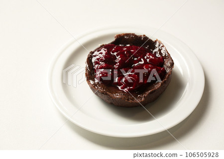 Delicious chocolate dessert with lingonberry jam on a plate 106505928