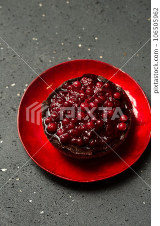 Delicious chocolate dessert with lingonberry jam on a plate on a dark background, top view Delicious chocolate dessert with lingonberry jam on a plate on a dark background, top view 106505962