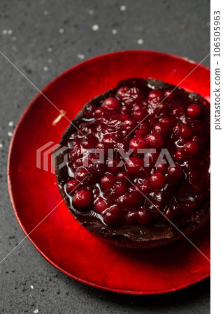 Delicious chocolate dessert with lingonberry jam on a dark background, top view Delicious chocolate dessert with lingonberry jam on a dark background, top view 106505963
