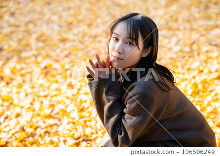 Young woman enjoying autumn leaves hunting Young woman enjoying autumn leaves hunting 106506249