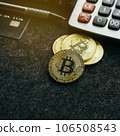 Gold bitcoin coin on office desk with calculator, credit card and pen.  106508543