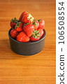 Strawberry full in black ceramic bowl on wood background with selective focus 106508554