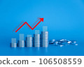 Stack of money coin on blue background with graph and red up arrow. Business and finance background with blue color filter.  106508559
