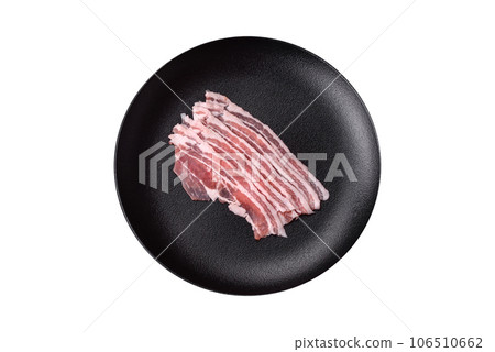 Fresh raw bacon cut into slices with salt, spices and herbs 106510662