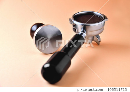 coffee horn with natural ground coffee and temper on an orange background coffee horn with natural ground coffee and temper on an orange background 106511713