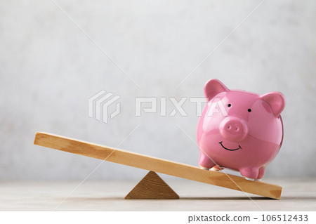 Ceramic piggy bank on wooden swing or scales on abstract background, business concept, template for designer 106512433