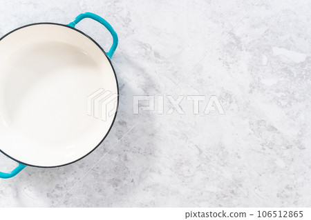 Clean cast iron enameled braiser on the kitchen counter. Clean cast iron enameled braiser on the kitchen counter. 106512865