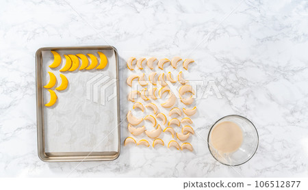Flat lay. Lemon wedge cookies with lemon glaze. Dipping lemon cookies into a lemon glaze. 106512877