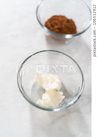 Greasing metal bundt cake pan with vegetable shortening and cocoa powder to bake gingerbread bundt cake with caramel filling. 106512912