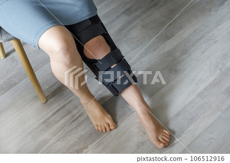 Female leg wearing knee brace closeup. Orthopedic Anatomic Orthosis. Braces  106512916