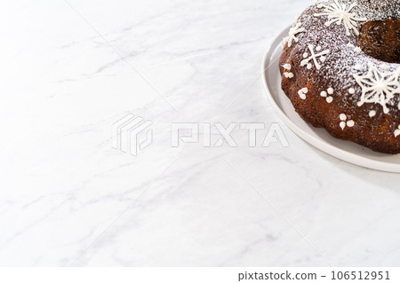 Gingerbread bundt cake with caramel filling, buttercream frosting, and powdered sugar dusting on the kitchen counter. Gingerbread bundt cake with caramel filling, buttercream frosting, and powdered sugar dusting on the kitchen counter. 106512951