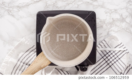 Flat lay. Step by step. Preparing chocolate ganache in a small saucepan. Flat lay. Step by step. Preparing chocolate ganache in a small saucepan. 106512959