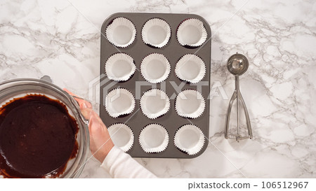 Flat lay. Step by step. Baking chocolate cupcakes. Scooping chocolate cupcake batter into a cupcake pan. 106512967