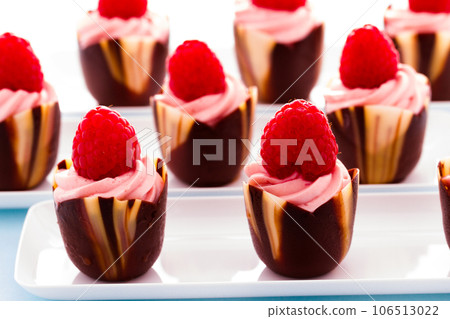 Small chocolate reaspherry tulip cups at dessert bar. Small chocolate reaspherry tulip cups at dessert bar. 106513022