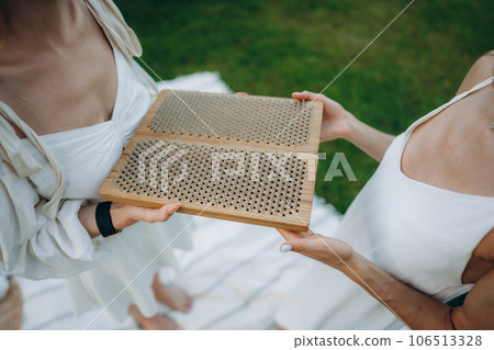 Standing on boards with nails. Young women practicing yoga and therapy in nature. 106513328