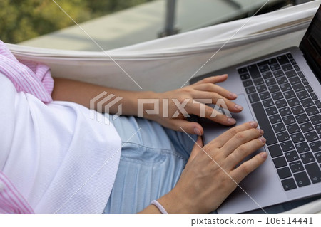 young woman freelancer working in hammock on terrace young woman freelancer working in hammock on terrace 106514441