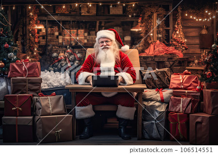 Santa Claus sits in the warehouse of his factory in front of laptop monitor. Santa Claus sits in the warehouse of his factory in front of laptop monitor. 106514551