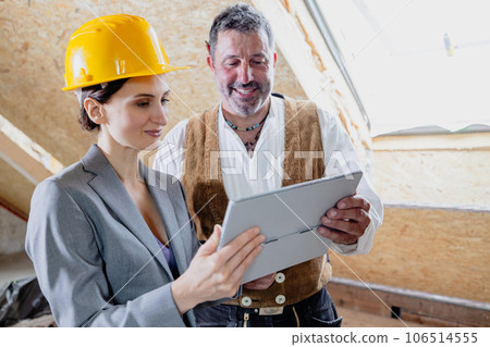 architect and carpenter on construction site with tablet computer 106514555
