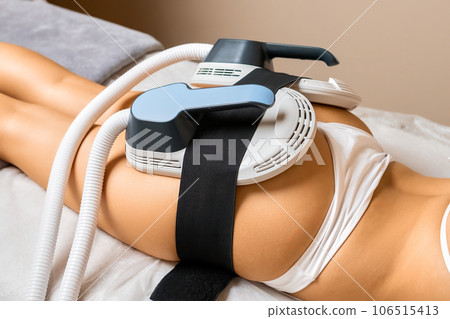 For precise body sculpting, dedicated equipment is positioned on the buttocks of a young woman. 106515413