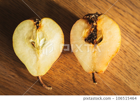 Damaged pears on wooden table. Peas with maggot on cutting board. Good and bad. Autumn farming. Difference concept. Raw food. Slices of sweet pear. Organic fruits. Spoiled fruits. Damaged pears on wooden table. Peas with maggot on cutting board. Good and bad. Autumn farming. Difference concept. Raw food. Slices of sweet pear. Organic fruits. Spoiled fruits. 106515464