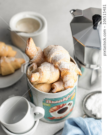 Homemade fresh croissants bagels in tin box with coffee for breakfast on white background. Cozy morning breakfast concept 106515481