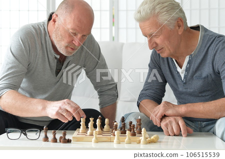 two old senior men playing chess at home 106515539