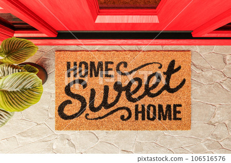 Home Sweet Home doormat on the porch at the red front door. 106516576
