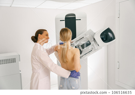 Female doctor prepairing woman before doing mammogram x-ray to check for breast cancer at hospital 106516635