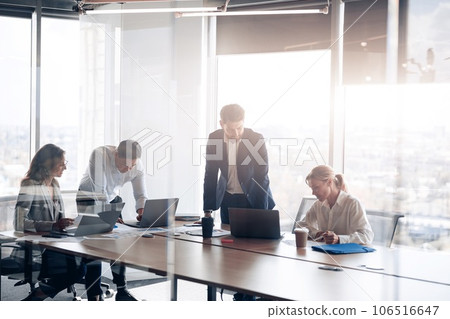 Team of young businessmen working and communicating together in office with panoramic windows 106516647