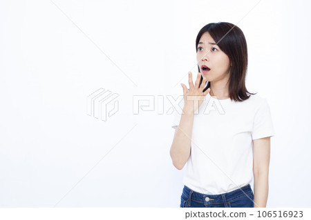 A woman in her thirties who is surprised in front of a white background 106516923