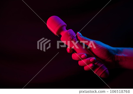 Woman holding a vibrator in neon pink and blue light. 106518768