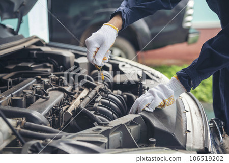 Close up Car Mechanic man hands repairing car auto repair shop. Man hands fixing machinery vehicle mechanical service. open vehicle hood checking up auto mobile. Vehicle Car maintenance engineer. 106519202
