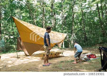 Parent and child enjoying the outdoors by camping Parent and child enjoying the outdoors by camping 106519301