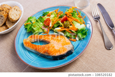 Lunch at Mediterranean restaurant.slice of fried salmon with salad of fresh vegetables. 106520182