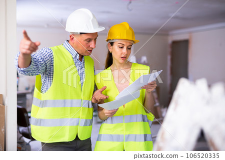 Woman architect and man engineer discussing work plan in apartment Woman architect and man engineer discussing work plan in apartment 106520335