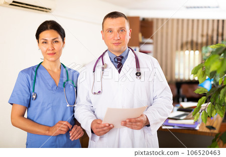 Two confident professional fellow doctors standing in office 106520463