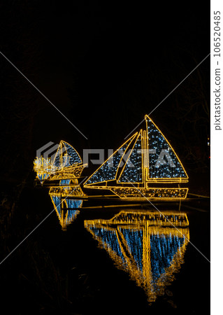 Small ships and Boats Holiday illuminated decorations in Oliva Park Gdansk Poland. Beautiful Christmas fair at night. Advent winter time in Europe background. Christmas Markets in December Small ships and Boats Holiday illuminated decorations in Oliva Park Gdansk Poland. Beautiful Christmas fair at night. Advent winter time in Europe background. Christmas Markets in December 106520485