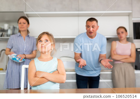 Upset preteen girl listening to reprimand of displeased father and mother Upset preteen girl listening to reprimand of displeased father and mother 106520514